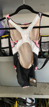 Load image into Gallery viewer, The back view of a floral print dance leotard on a hanger, showcasing a racerback design with a keyhole cutout.