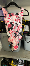 Load image into Gallery viewer, A sleeveless dance leotard featuring a vibrant pink, black, and white floral print, hanging on a black hanger.