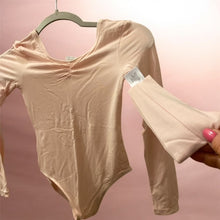 Load image into Gallery viewer, Ek light pink long-sleeve leotard, jo hanger par latki hui hai aur ek floor par rakhi hui hai.